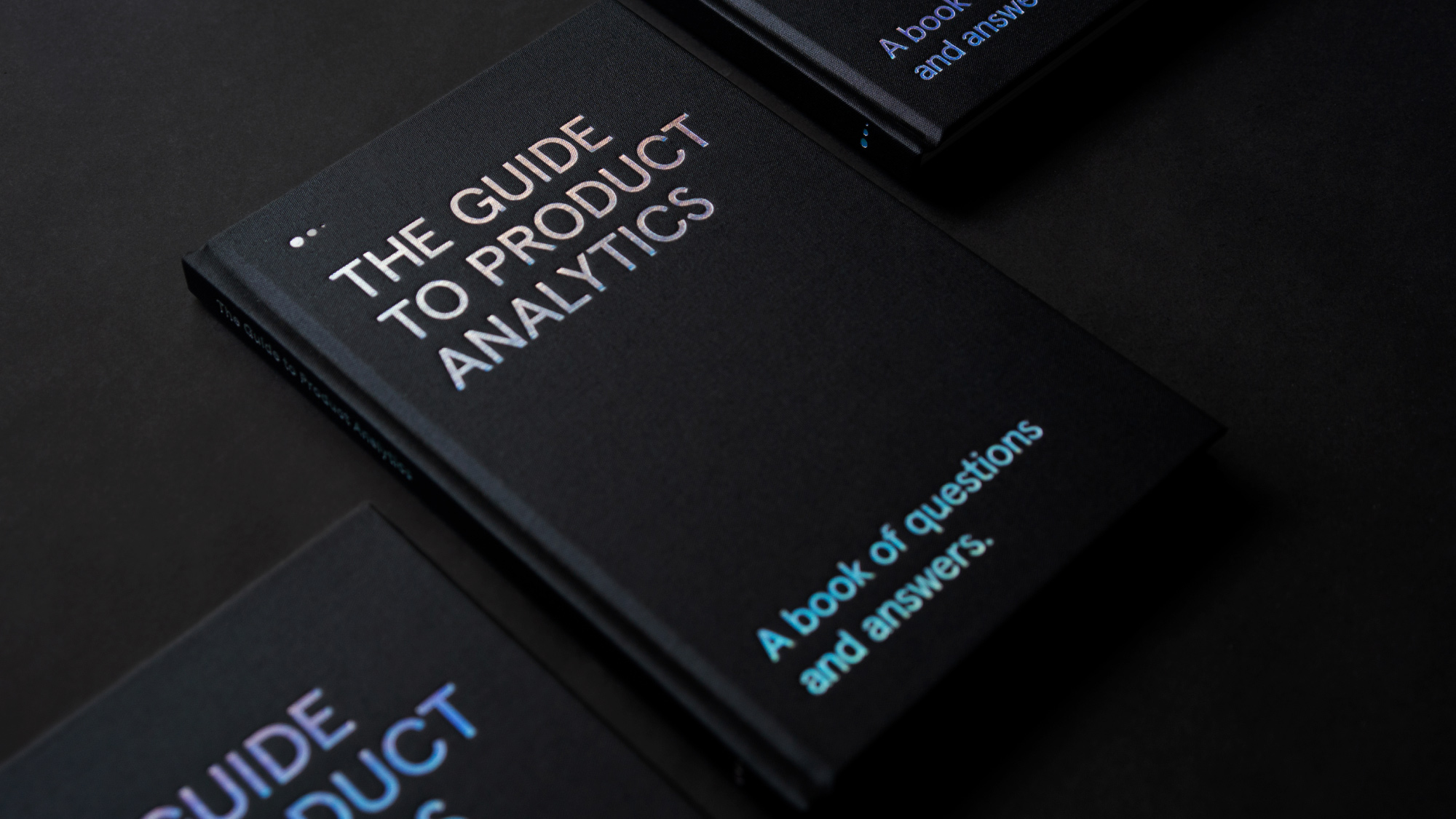 3 Guide to Product Analytics books lined up diagonally on a black background