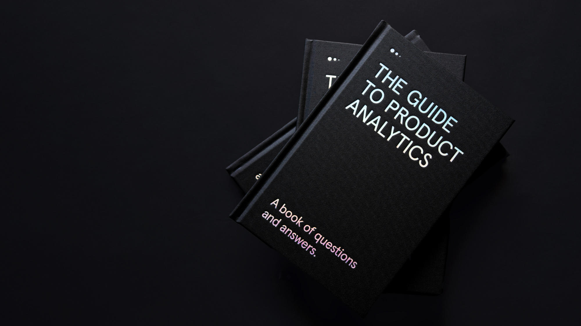 3 Guide ot Product Analytis books stacked on top of each other on a black background