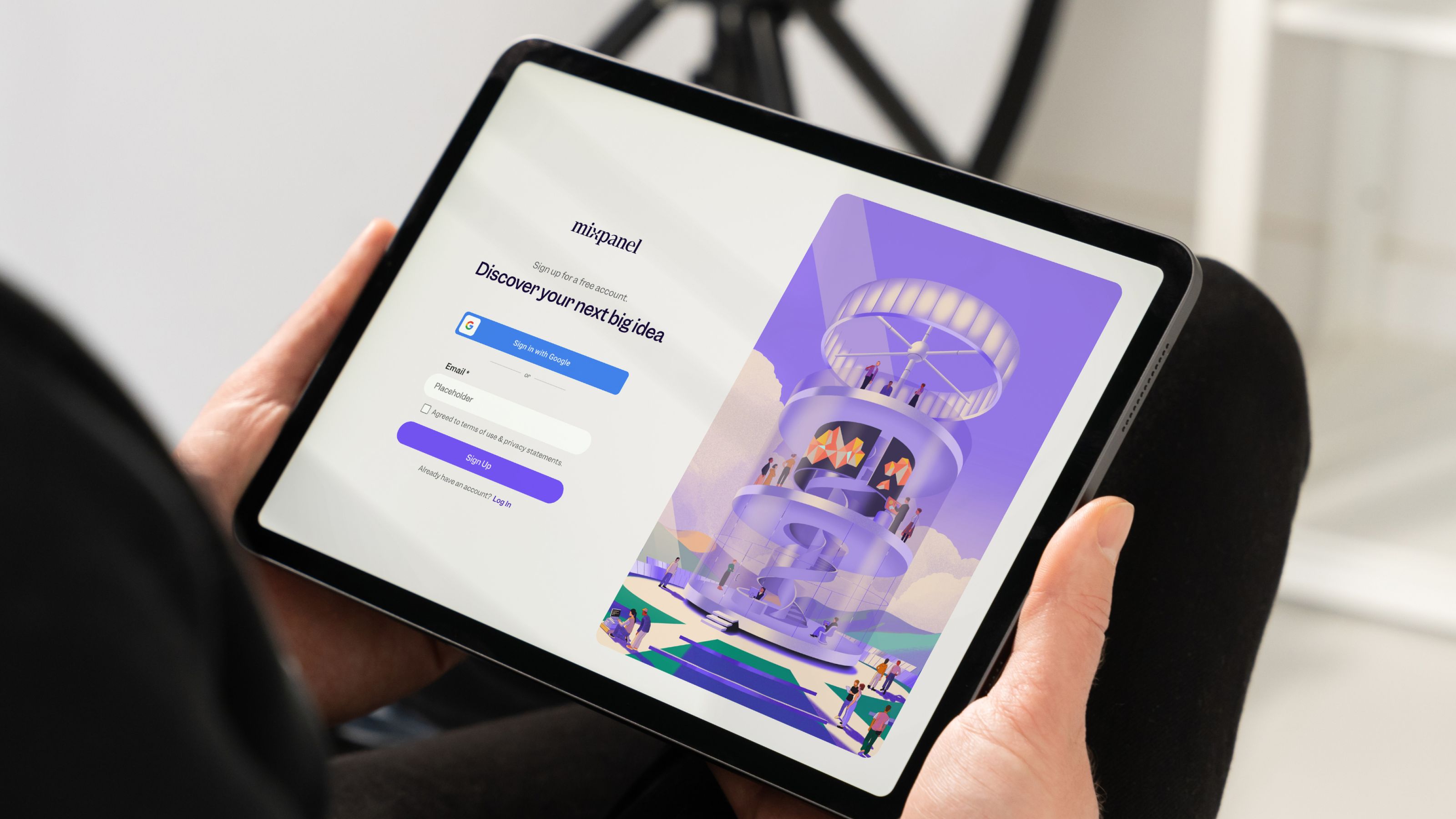 Mockup of person holding a tablet with the Mixpanel signup page featured