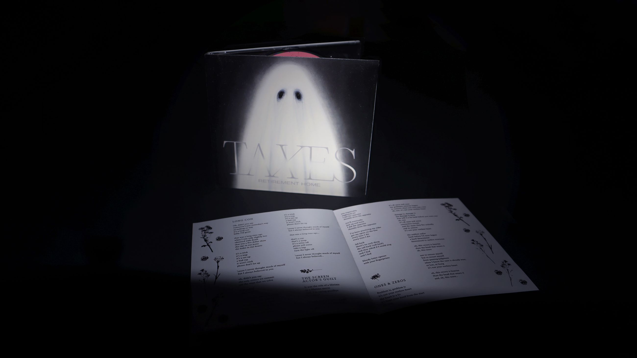 Photo of the CD packaging (digipak) is placed vertically with the booklet open and showing the lyrics.